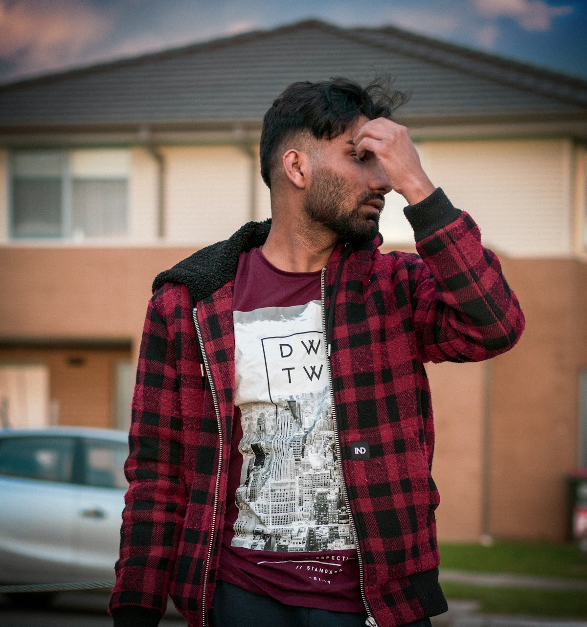 a man standing in front of a building holding his head